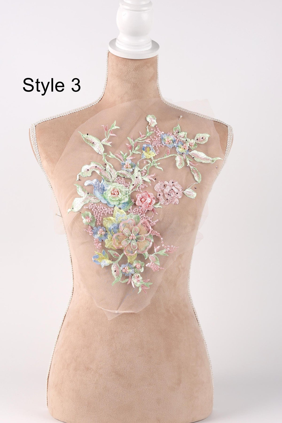 A mannequin with a floral embroidered patch on its bust, featuring a variety of colorful flowers and leaves.