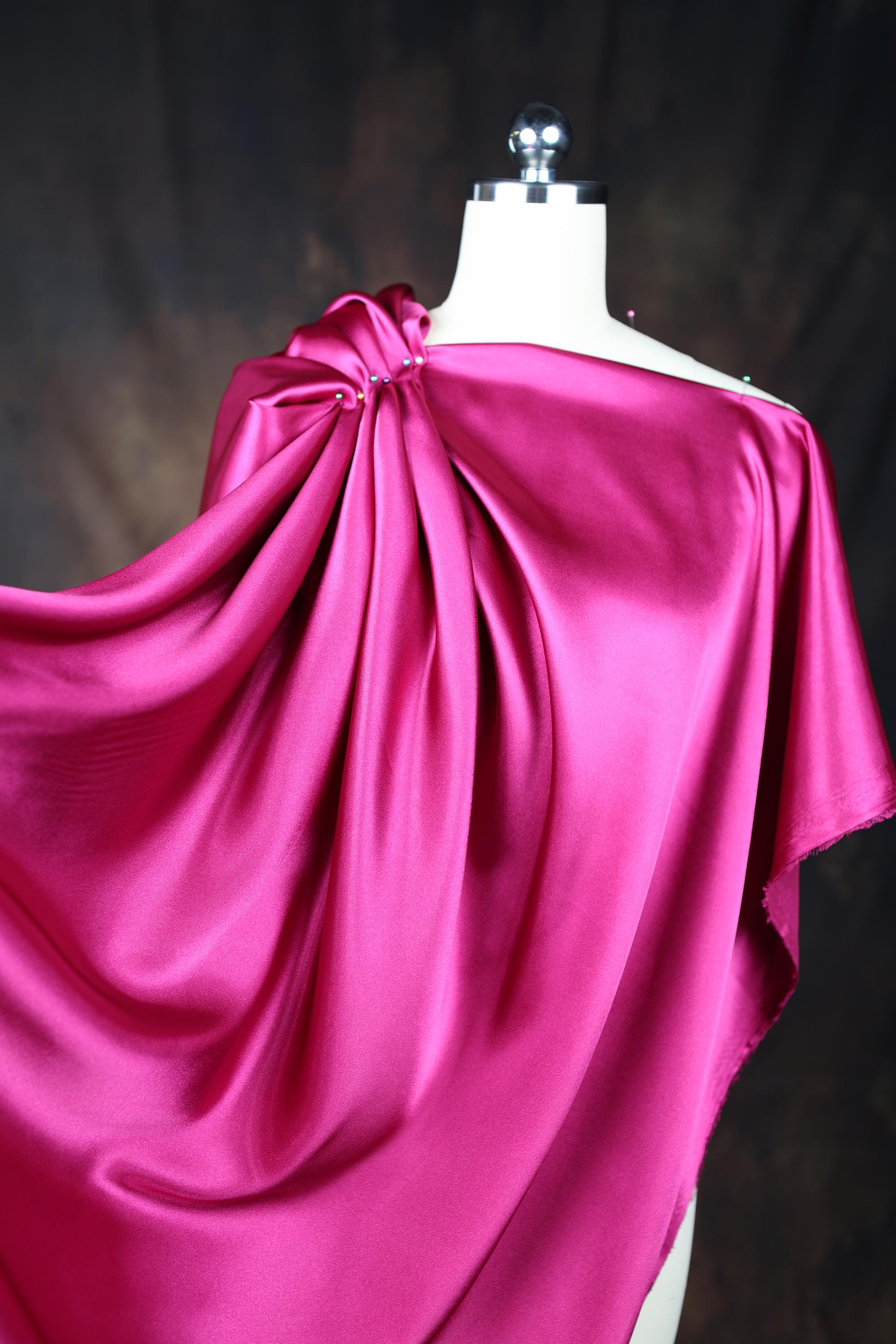a dress on a mannequin with a pink cloth draped over it