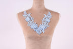 A mannequin wearing a necklace with blue floral embroidery.