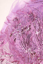 a close-up view of a fabric with a pink and purple floral pattern, featuring sequins and beads that create a visually striking and intricate design.