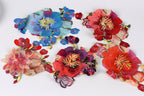 a variety of colorful, intricately embroidered flowers in different shapes and sizes, arranged on a white background.
