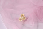 a delicate arrangement of three small white flowers against a soft pink background.