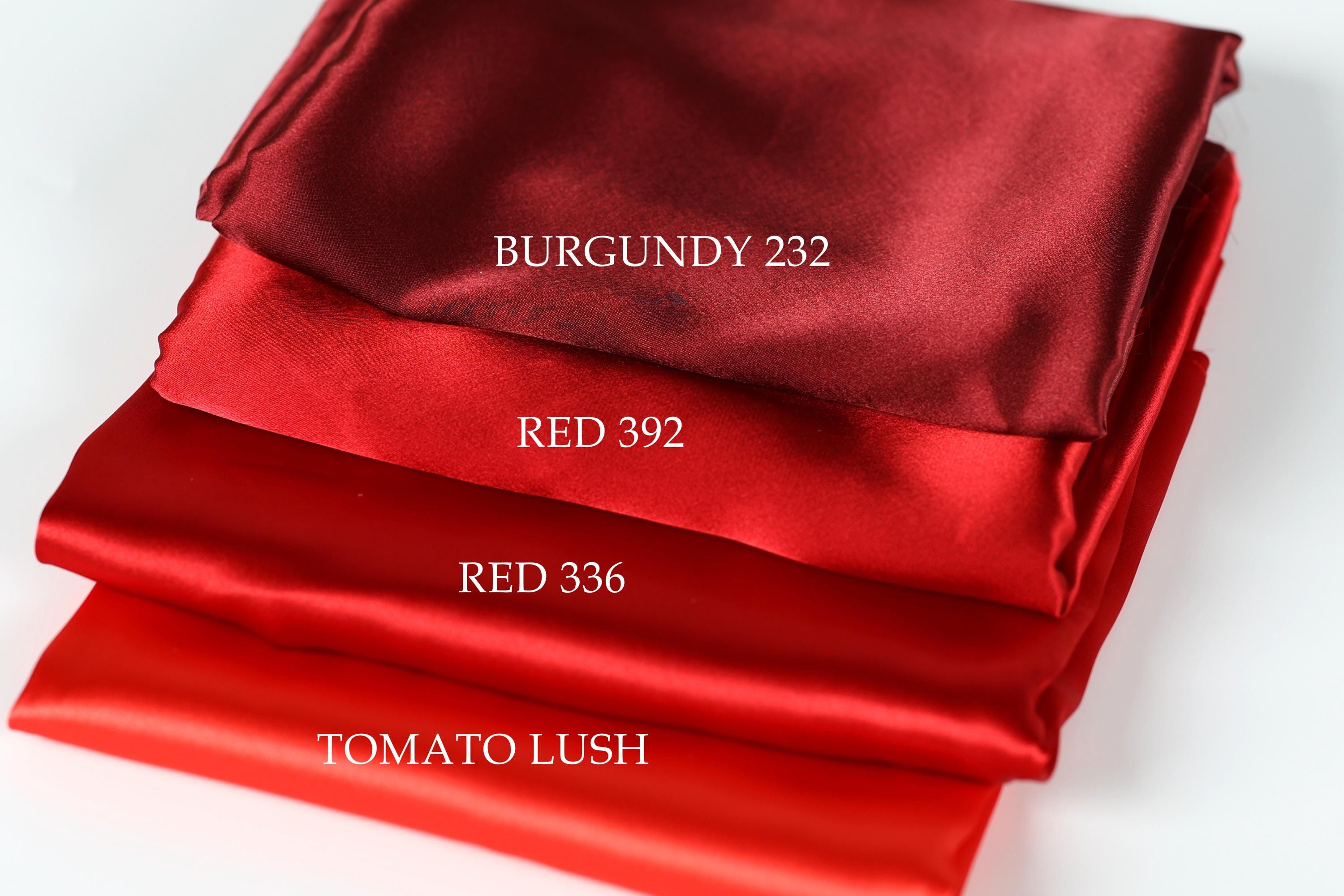 a stack of four red satin fabrics, each with a different color: Burgundy, Red, Red, and Tomato Lush.