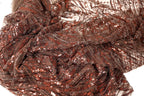 a close-up view of a fabric with a brown and red color scheme, featuring a pattern of sequins or beads. The fabric appears to be made of a sheer material, giving it a delicate and intricate appearance.