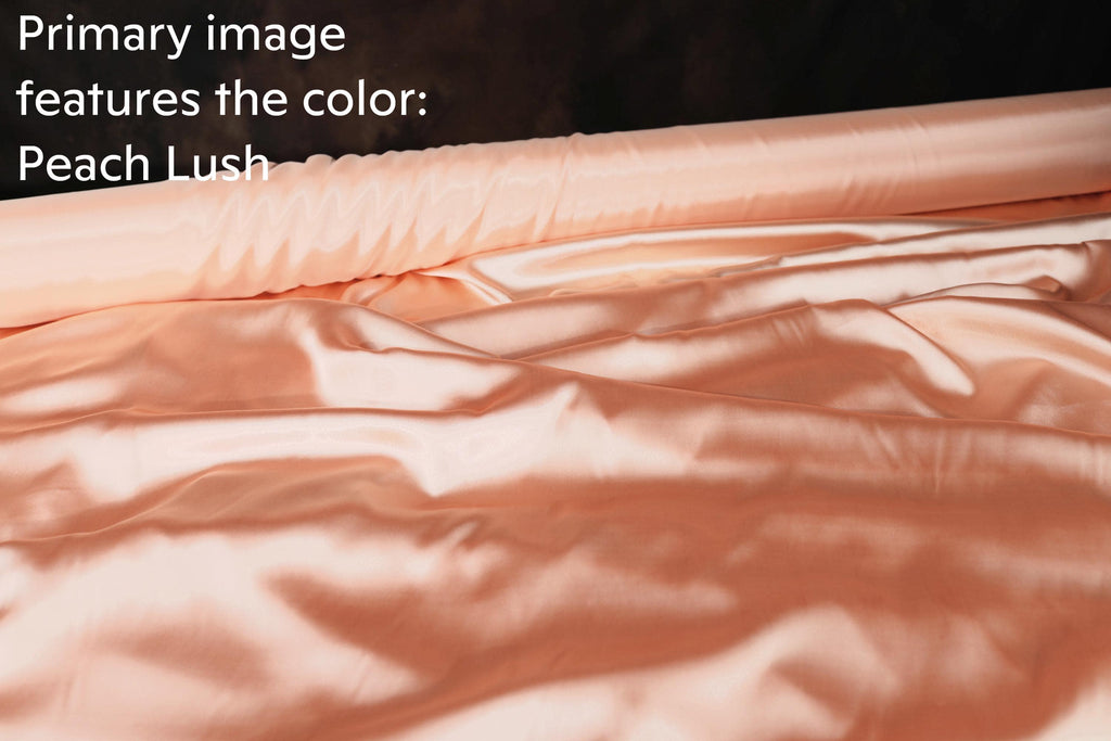 a close-up view of a soft, flowing fabric with a peach-colored hue, which appears to be a satin or satin-like material.
