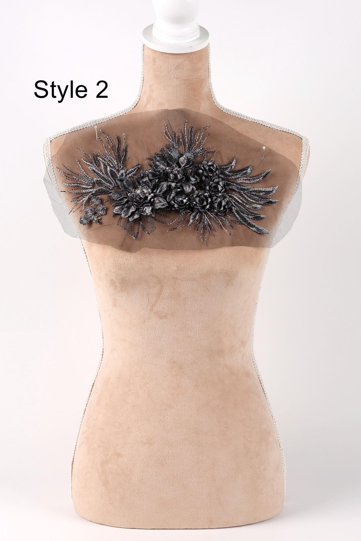 A mannequin with a decorative fabric patch on its bust area, featuring a floral design.