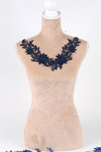 A mannequin wearing a necklace with blue floral embroidery.