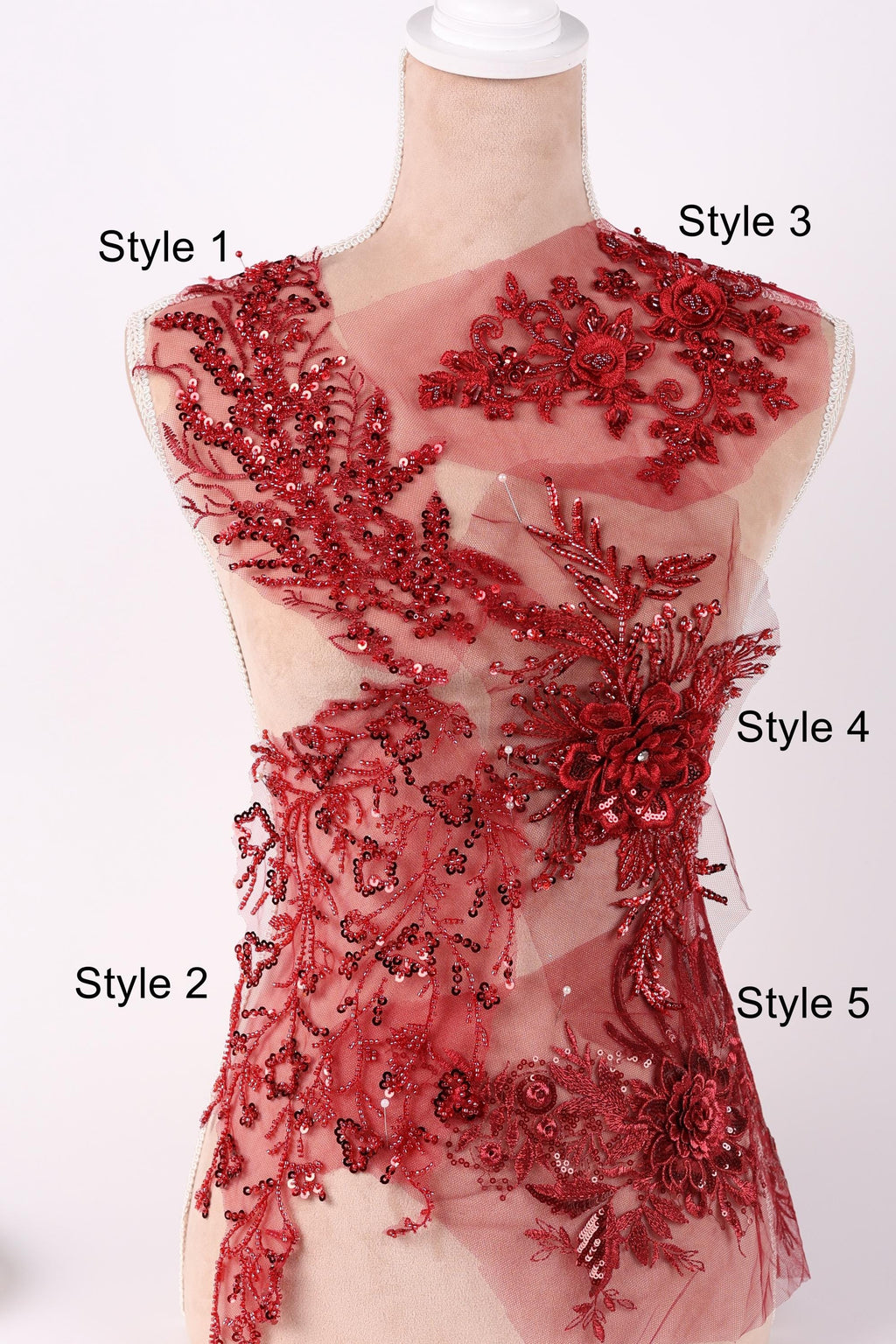 A mannequin wearing a red dress with intricate red floral and sequin embellishments.