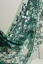 a close-up view of a fabric with a green and silver sequin pattern, creating a visually striking and intricate design.