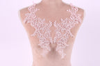 A mannequin wearing a pink lace dress with intricate floral patterns.