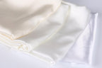 a close-up view of three white fabric pieces, possibly silk or satin, arranged in a horizontal line.