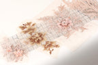 a collection of delicate, intricate floral embroidery pieces, including a large pink flower with a gemstone at the center. The embroidery appears to be made from a light-colored fabric, possibly lace or chiffon, and is displayed on a white background.