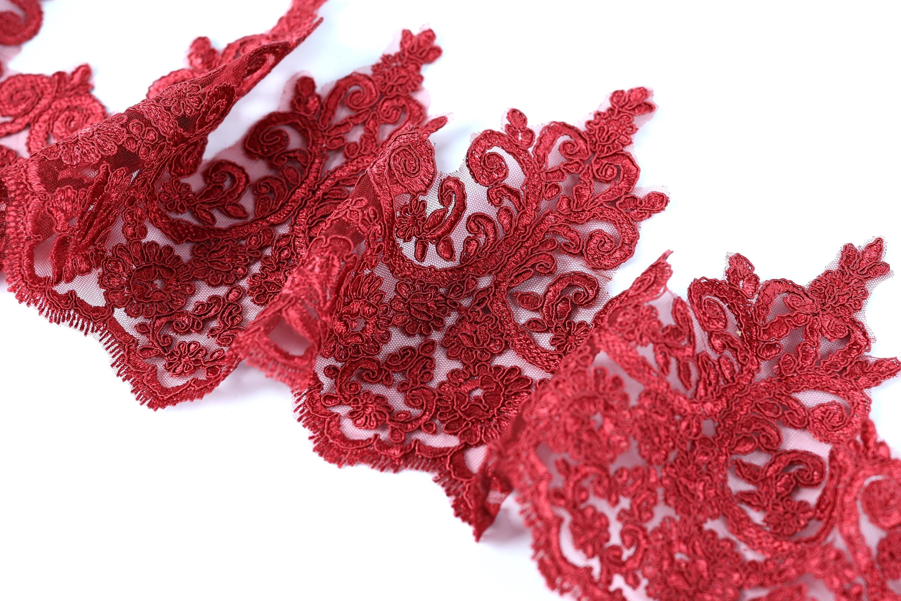 a close-up view of a piece of red lace with intricate floral patterns.