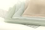 a close-up view of a stack of fabric swatches, with a clear ruler placed on top of them.