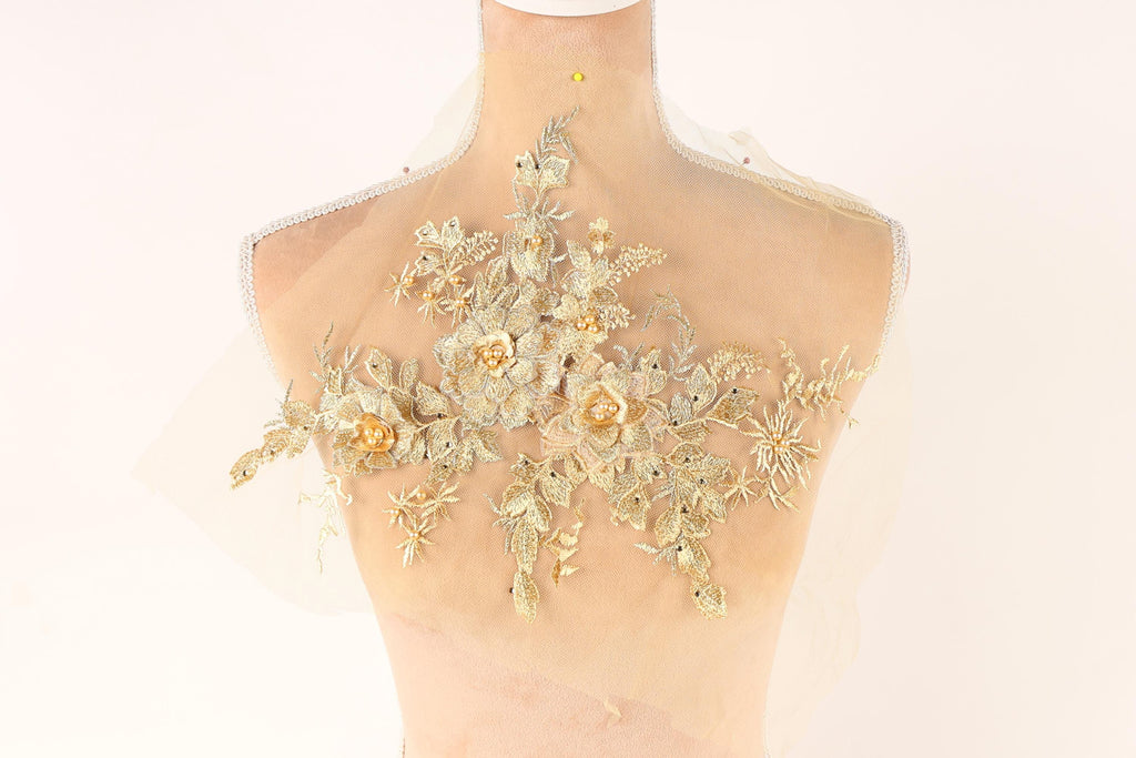 A mannequin with a delicate, intricate floral embroidery on its back.