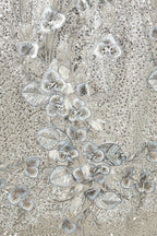 The image is a close-up of a fabric with a floral pattern, featuring a variety of small, intricately designed flowers and leaves in shades of gray and white.