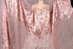 a pink and gold sequined dress with a sheer overlay, displayed on a mannequin.