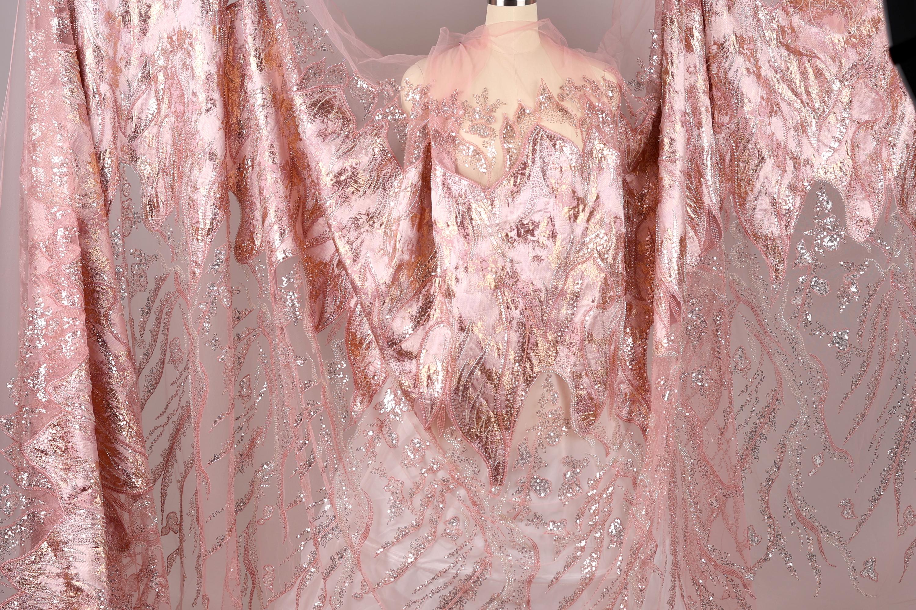 a pink and gold sequined dress with a sheer overlay, displayed on a mannequin.