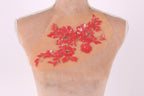 A mannequin with a beige fabric on its chest, adorned with a vibrant red floral embroidery design.