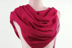 A mannequin wearing a vibrant red scarf draped over its shoulders.