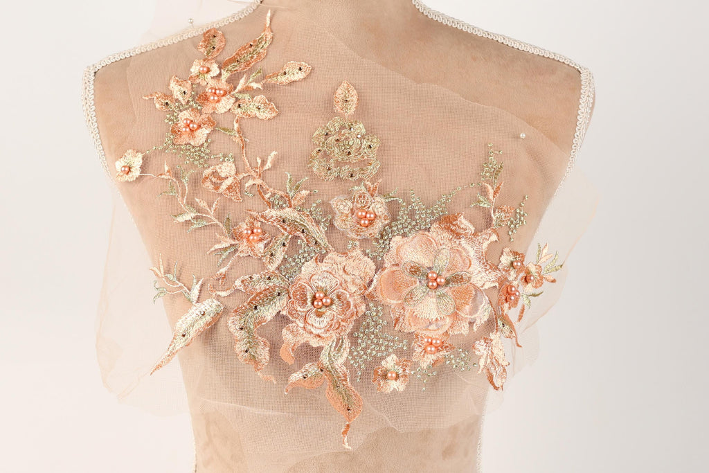 A mannequin bust with a delicate, intricate floral embroidery design on the back.