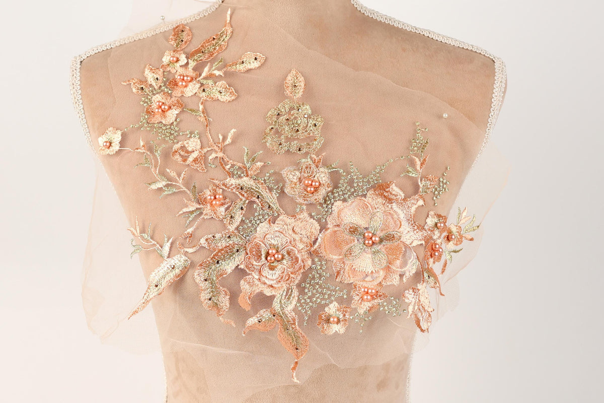 A mannequin bust with a delicate, intricate floral embroidery design on the back.