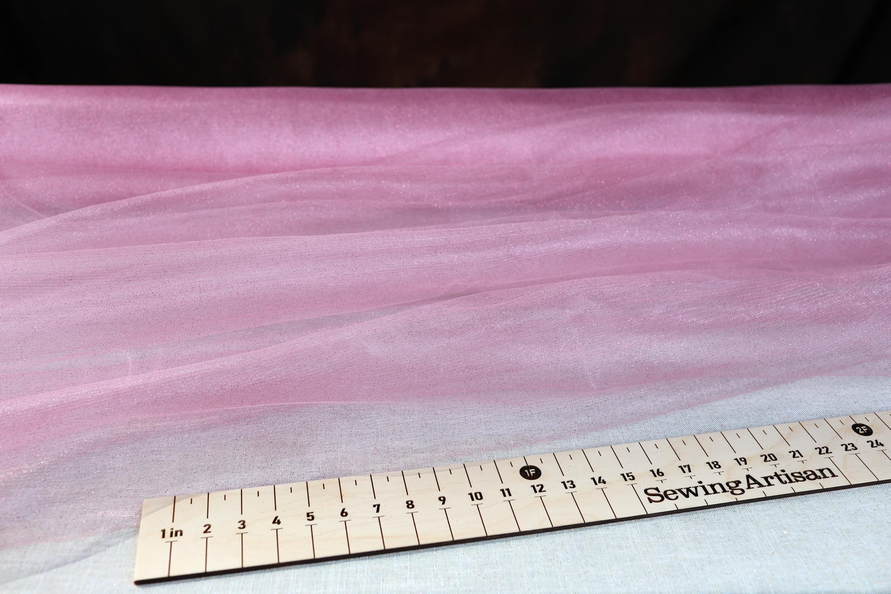 a ruler sitting on top of a pink sheet