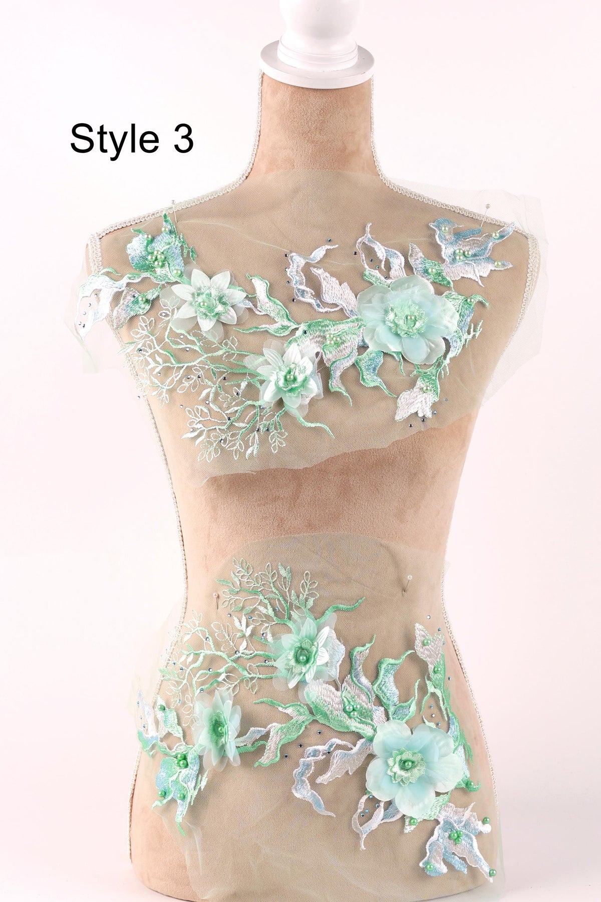 A mannequin wearing a dress with a floral pattern on the bodice and skirt.