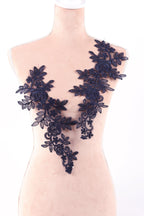 A mannequin wearing a dress with a floral lace design on the bust area.