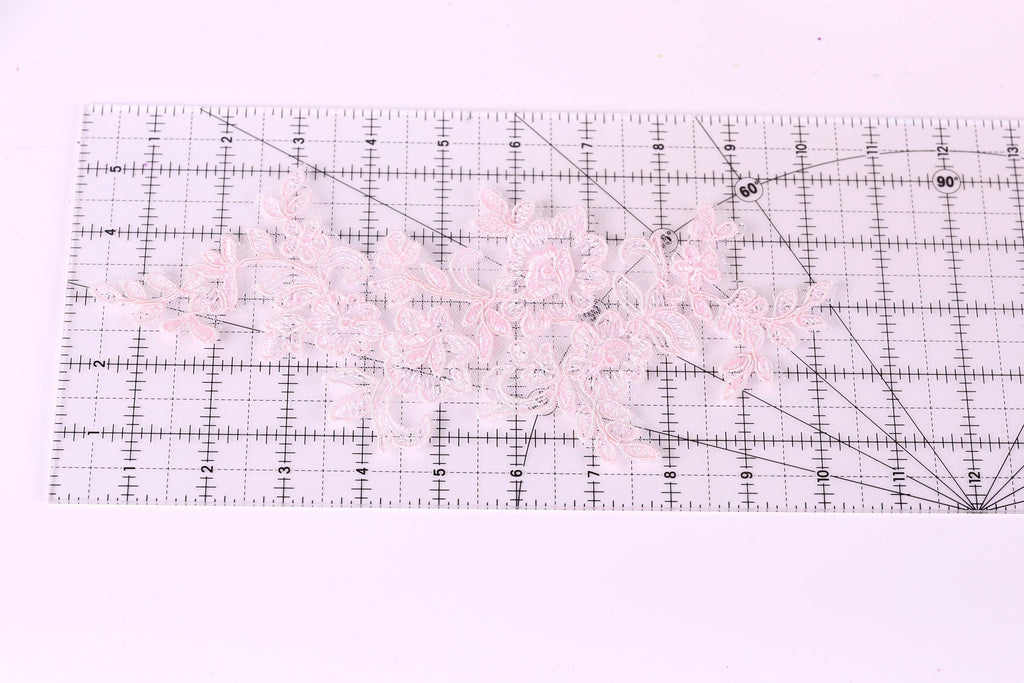 a clear ruler with a pink lace pattern placed on it.