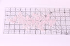 a clear ruler with a pink lace pattern placed on it.