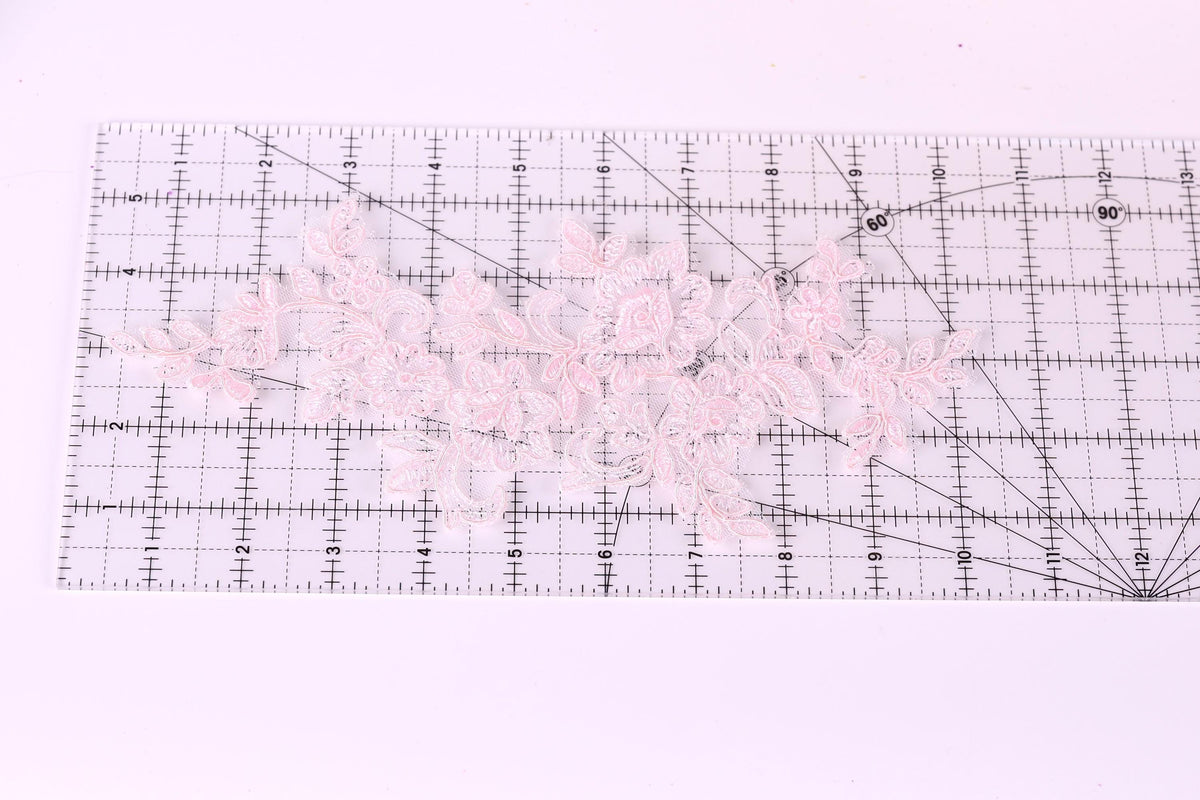 a clear ruler with a pink lace pattern placed on it.