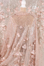 a pink sequin fabric with a floral pattern, including pink flowers and leaves. The fabric appears to be a sheer, sheer fabric with a delicate, lace-like appearance.