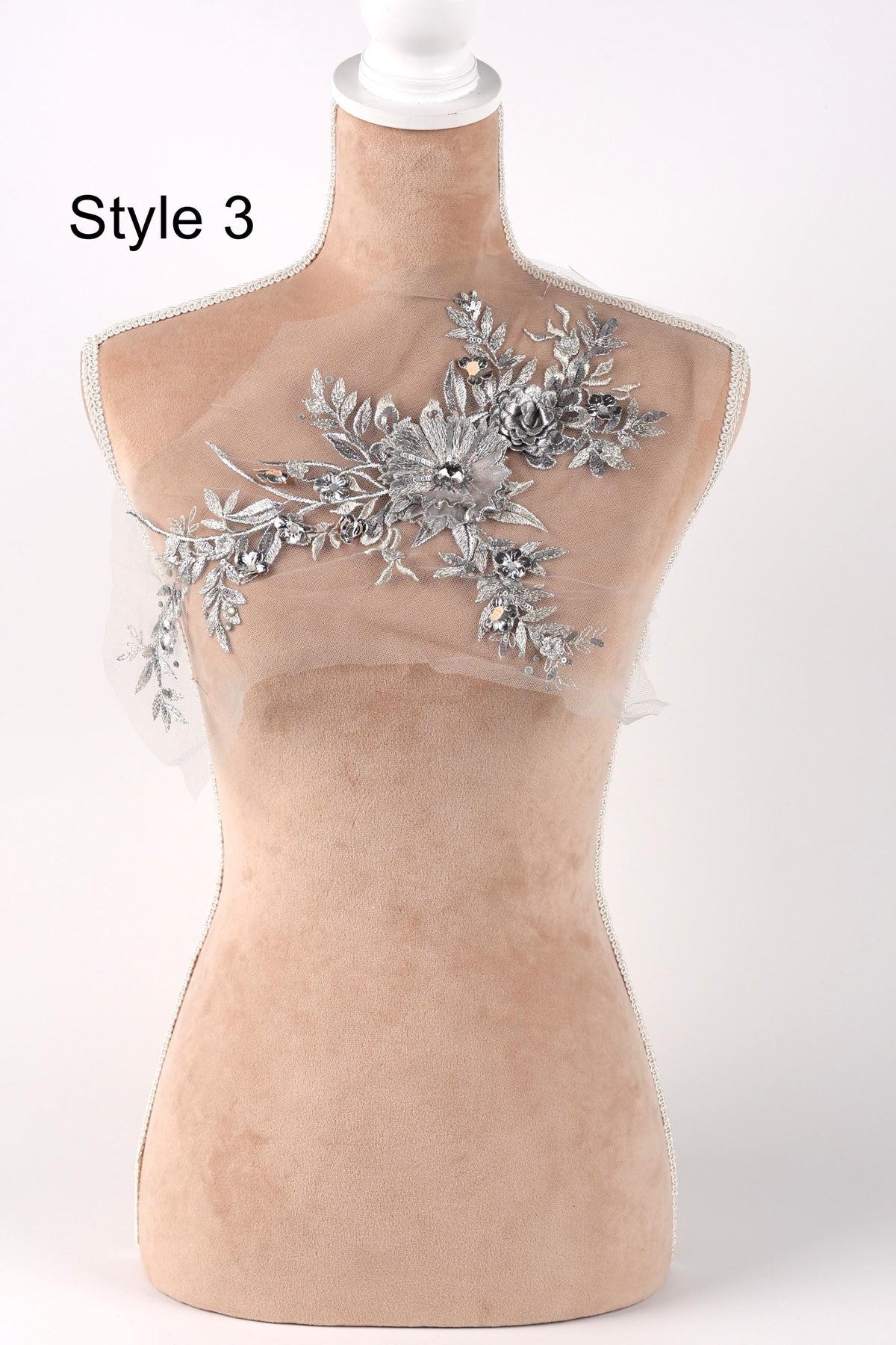 A mannequin with a decorative floral embellishment on its bust.