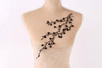 A mannequin with a black floral embroidered on its back.