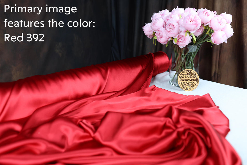 the color red, with a bouquet of pink flowers in a glass vase placed on a white tablecloth.