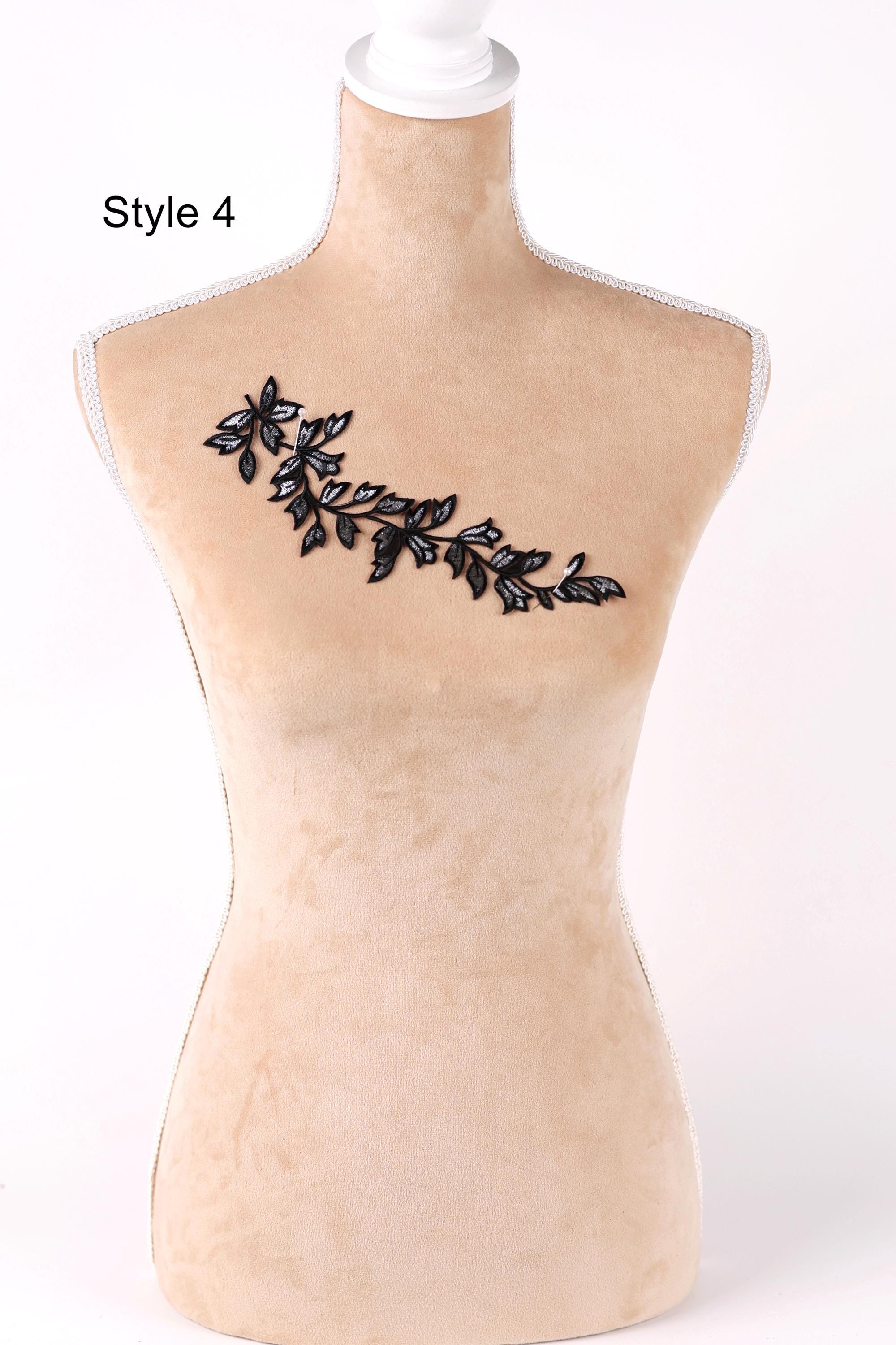 A mannequin with a decorative leaf pattern on its bust.