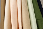A close-up view of various fabric swatches in different colors, including peach, beige, and green.