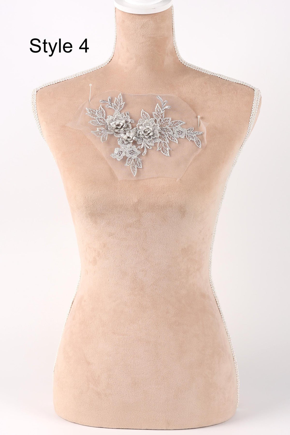 A mannequin with a decorative floral piece on its chest.