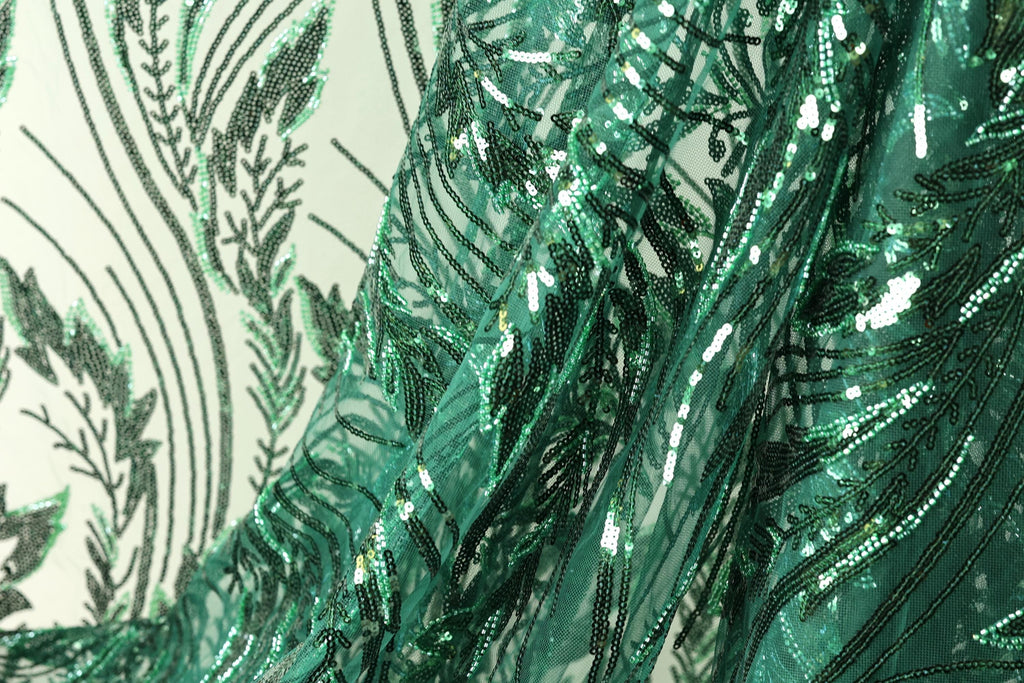 a close-up view of a fabric with a green and black sequin pattern, creating a visually striking and intricate design.