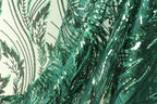 a close-up view of a fabric with a green and black sequin pattern, creating a visually striking and intricate design.