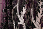 a close-up view of a fabric with a floral pattern in shades of purple and black, adorned with sequins.