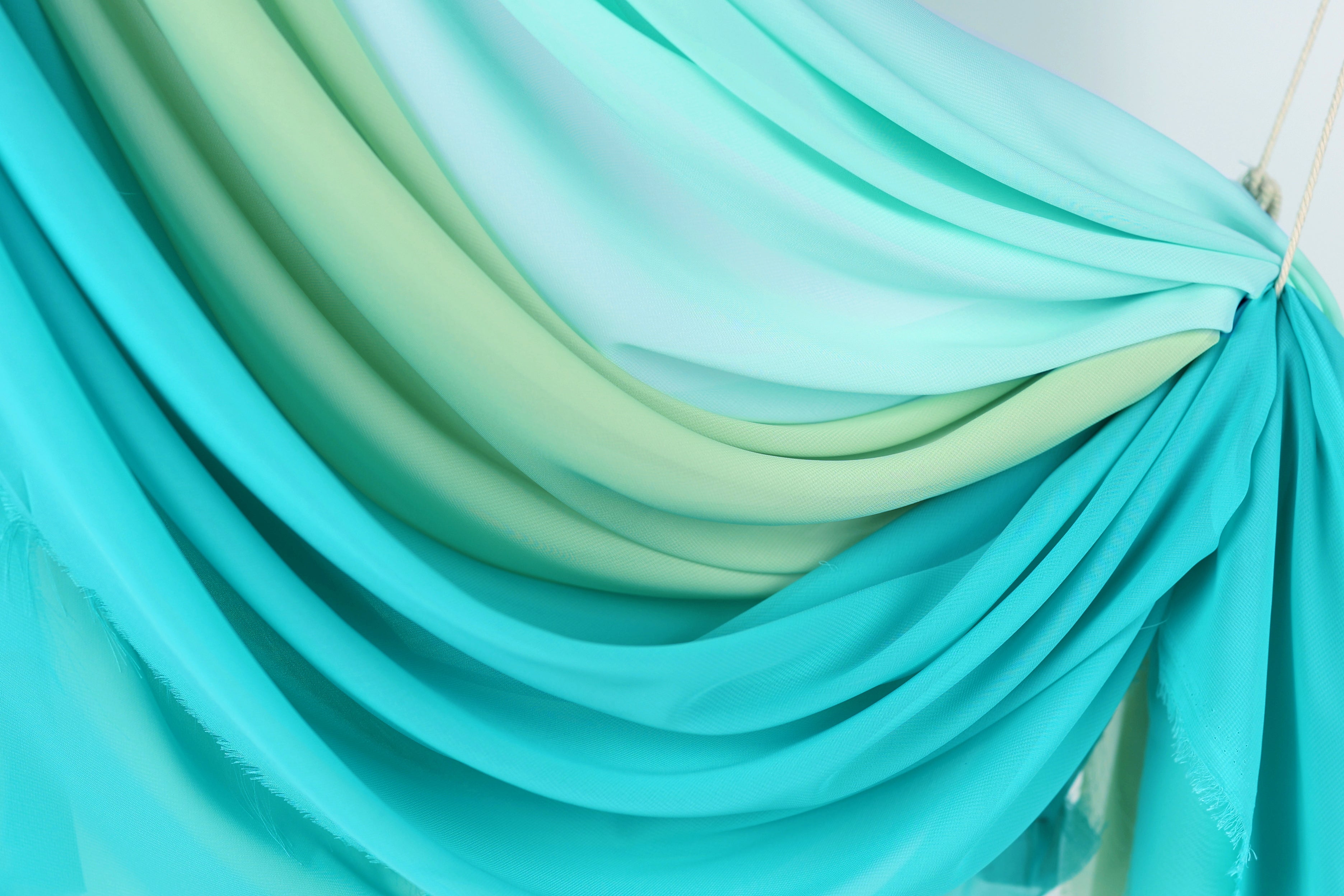 a close-up view of a fabric with a gradient of blue and green colors, creating a visually appealing and textured appearance.