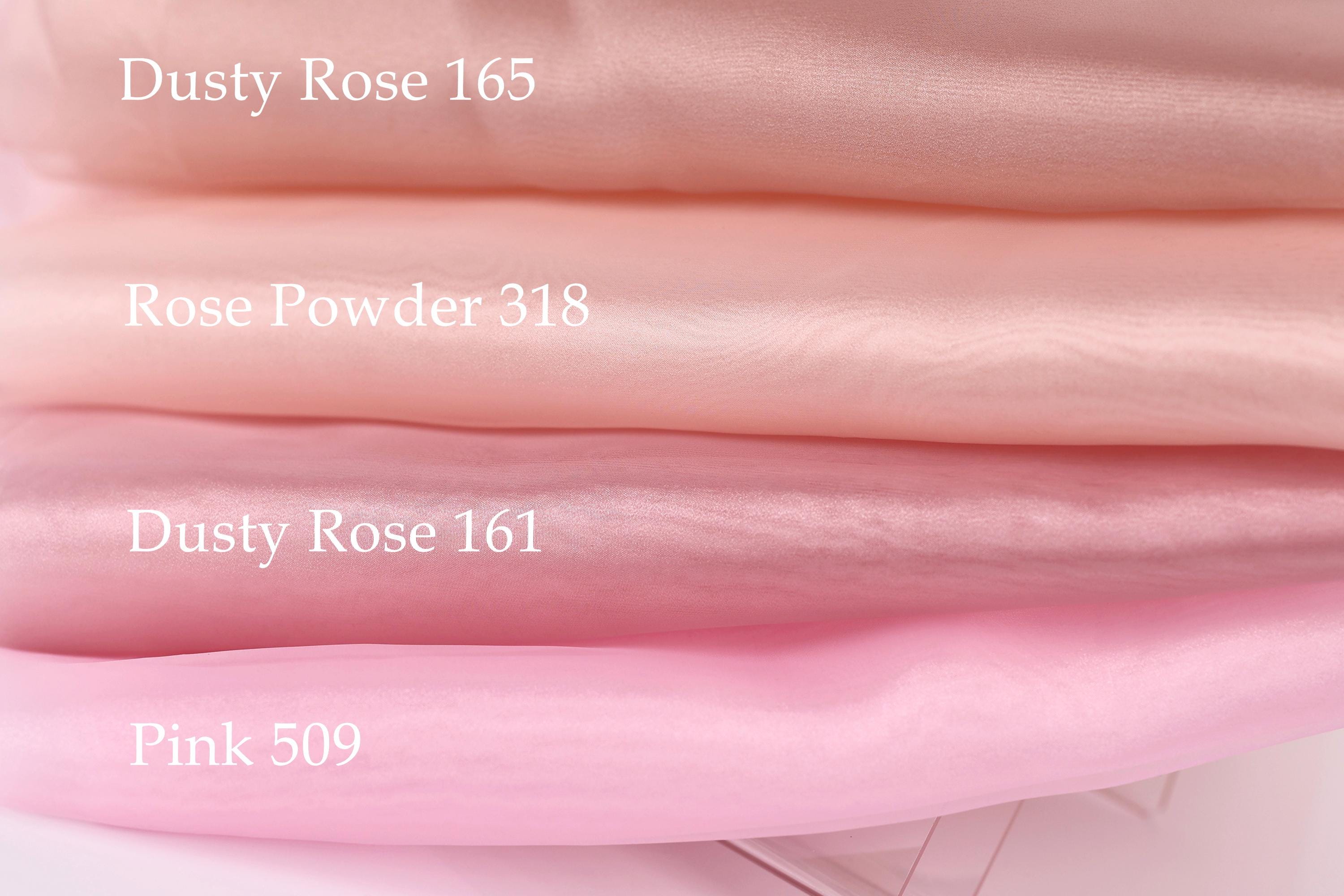 a close-up of a stack of fabric swatches in various shades of pink, with text labels indicating the color and material of each swatch.