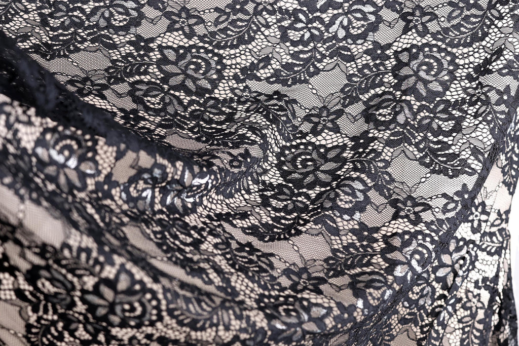 a close-up view of a black and white lace fabric with intricate floral patterns.