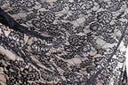 a close-up view of a black and white lace fabric with intricate floral patterns.
