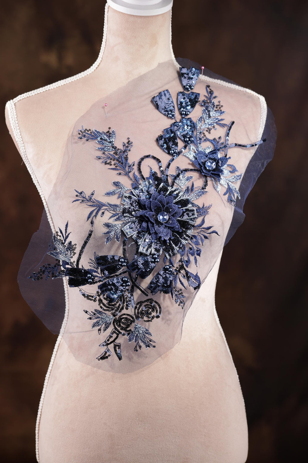 A mannequin wearing a dress with a floral pattern on the shoulder area.