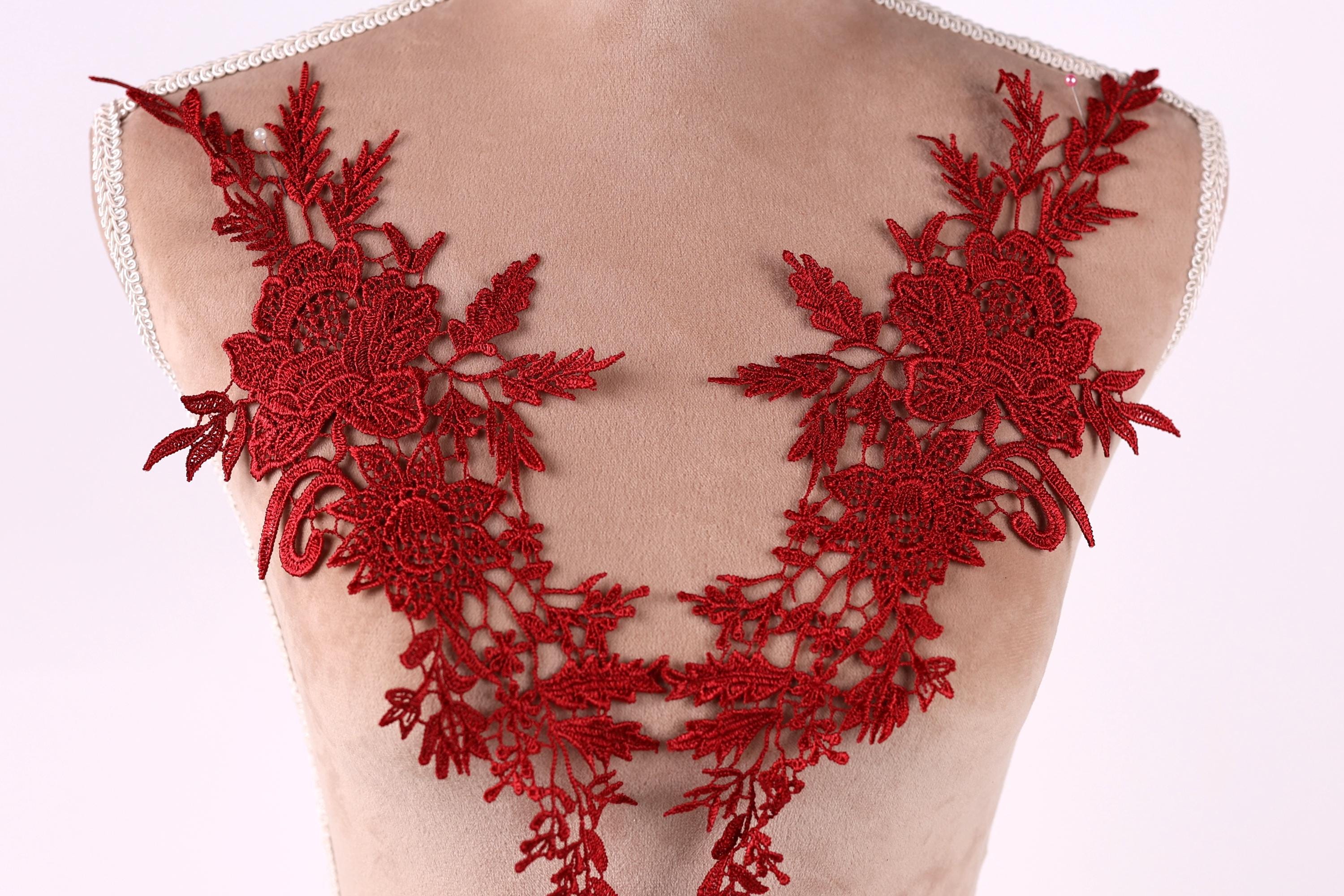 A mannequin torso with red floral embroidery on the bust area.