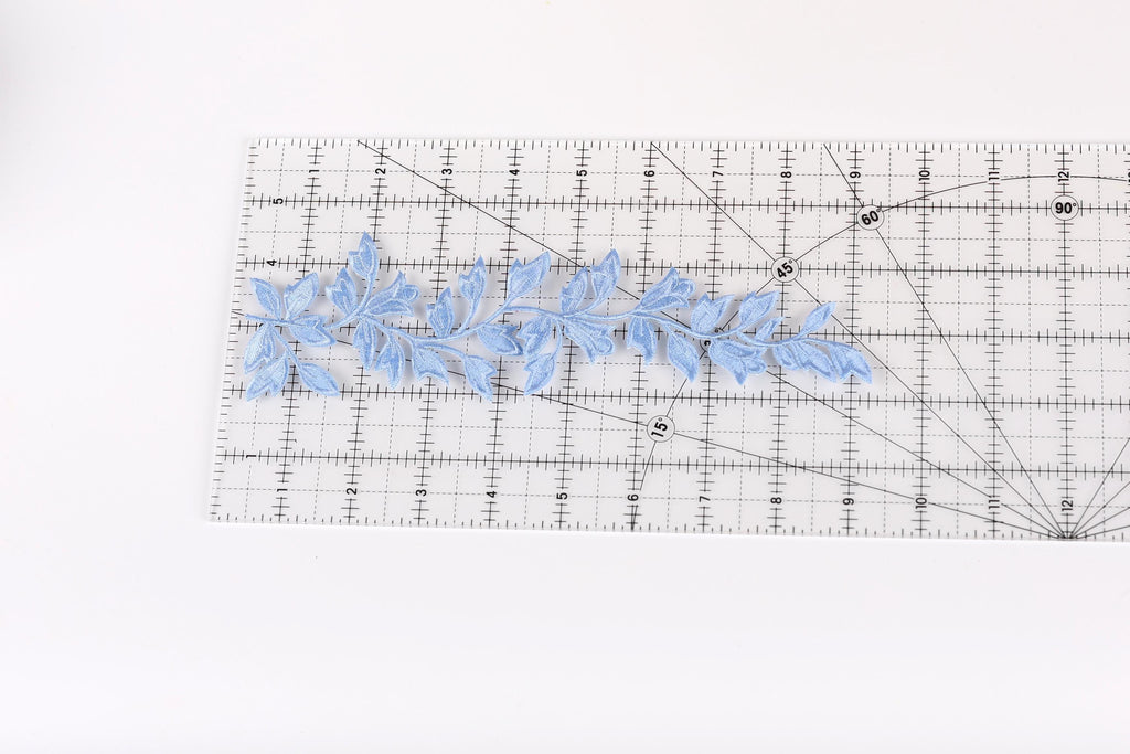a clear ruler with a blue leaf pattern placed on it.