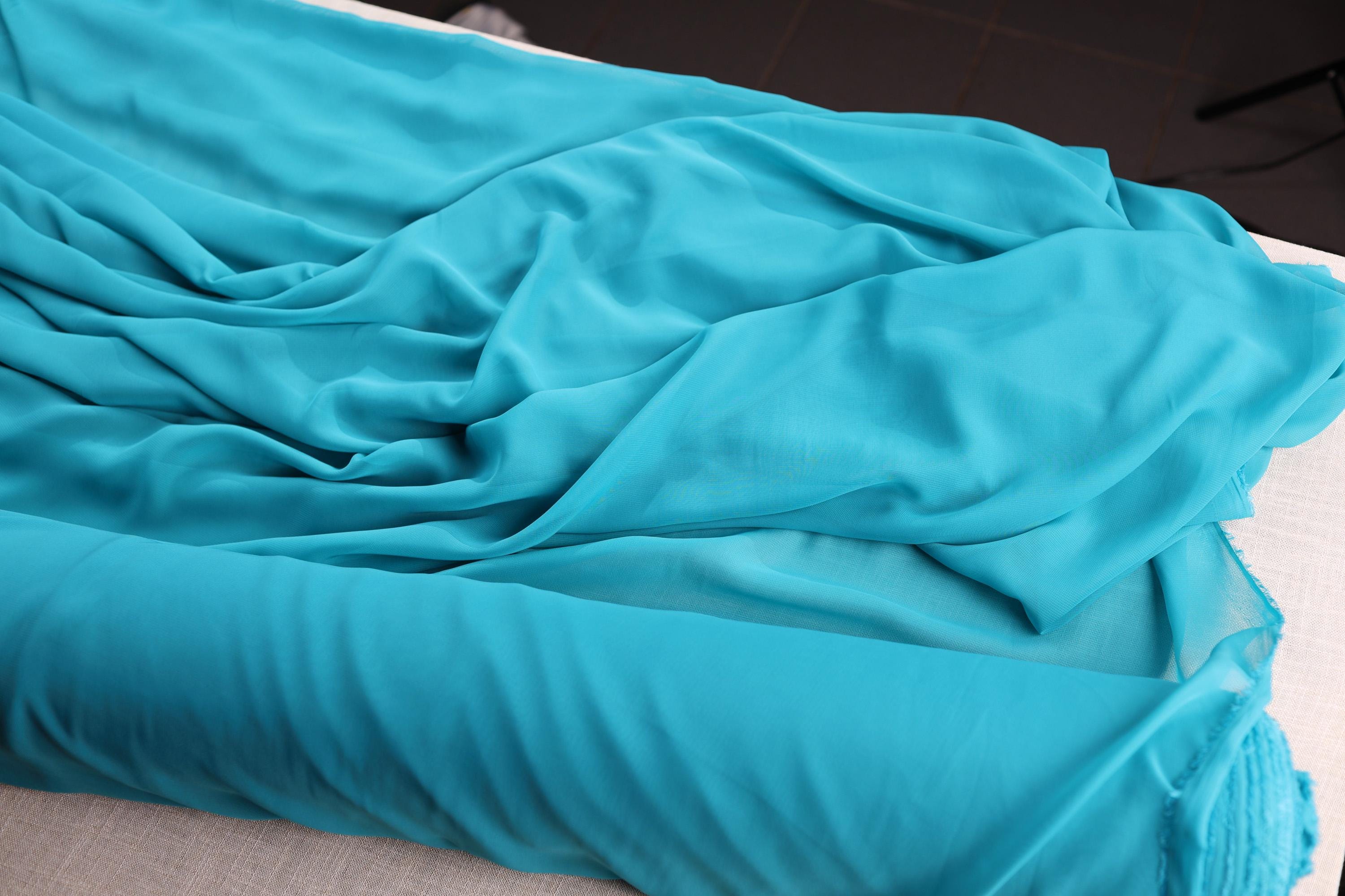 a bed with a blue comforter on top of it